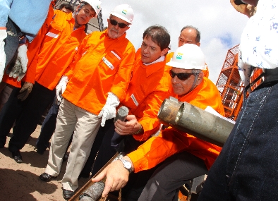 Autoridades e operários com uma tubulação na cerimônia de lançamento da pedra fundamental da Refinaria Premium II, em 2010